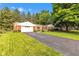 Red brick home with a long driveway, complemented by a lush green lawn and mature trees, creating a welcoming view at 703 Chapel Hill W Dr, Indianapolis, IN 46214