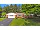 Beautiful red brick home with an attached garage, complemented by a lush green lawn and mature trees at 703 Chapel Hill W Dr, Indianapolis, IN 46214