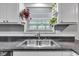 Bright kitchen features a stainless steel sink and a window with natural lighting and shelves for potted plants at 703 Chapel Hill W Dr, Indianapolis, IN 46214