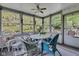 Inviting sunroom featuring wicker seating and abundant natural light, perfect for relaxing and enjoying the scenery at 703 Chapel Hill W Dr, Indianapolis, IN 46214