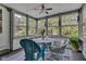 Bright sunroom features wicker seating, a round table and large windows offering a serene atmosphere to enjoy the outdoors at 703 Chapel Hill W Dr, Indianapolis, IN 46214