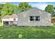 A home's rear exterior shows a wood deck and light yellow siding, and lush green lawn at 7600 S Oak Dr, Indianapolis, IN 46227