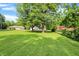 A backyard features sprawling lawn space, mature trees and multiple homes on the same block at 7600 S Oak Dr, Indianapolis, IN 46227