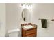 Cozy bathroom with a wooden vanity, round mirror, granite countertop, and white toilet at 7600 S Oak Dr, Indianapolis, IN 46227