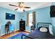 Comfortable bedroom featuring a ceiling fan, hardwood floors, and a soothing blue color scheme for a peaceful ambiance at 7600 S Oak Dr, Indianapolis, IN 46227