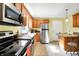 Well-lit kitchen with wooden cabinets, granite countertops, stainless steel appliances, and tiled floors at 7600 S Oak Dr, Indianapolis, IN 46227