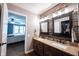 Well-lit bathroom with double sink vanity, decorative wood accent wall, and view to bedroom at 7686 Micawber Ct, Indianapolis, IN 46256