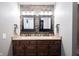 Double sink vanity with granite countertop and dark wood cabinets in the bathroom at 7686 Micawber Ct, Indianapolis, IN 46256