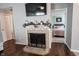 Cozy fireplace with decorative accents, a mounted TV, and a view into the adjacent bedroom, creating a warm ambiance at 7686 Micawber Ct, Indianapolis, IN 46256