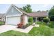 Beautiful ranch style home showcasing a two-car garage, brick accents, and mature landscaping at 7686 Micawber Ct, Indianapolis, IN 46256