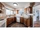 Well-appointed kitchen with warm wood cabinetry, laminate countertops, and white appliances, conveniently adjacent to the dining area at 7686 Micawber Ct, Indianapolis, IN 46256