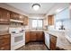 Bright kitchen showcasing wooden cabinets, granite countertops and white appliances at 7686 Micawber Ct, Indianapolis, IN 46256
