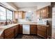 Cozy kitchen features wood cabinets, granite counters, and a window overlooking the backyard at 7686 Micawber Ct, Indianapolis, IN 46256
