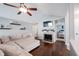 Cozy living room featuring a vaulted ceiling, ceiling fan, fireplace, and neutral-toned sectional sofa, perfect for relaxation at 7686 Micawber Ct, Indianapolis, IN 46256