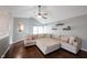 Bright living room featuring a vaulted ceiling, ceiling fan, neutral-toned sectional sofa, and stylish floating shelves at 7686 Micawber Ct, Indianapolis, IN 46256