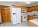 Functional kitchen with white appliances and natural wood cabinets at 7687 Sea Crest N Way, Noblesville, IN 46062
