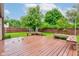 Spacious backyard featuring a wood deck, lush lawn, wooden fence, and mature trees offering a serene outdoor space at 7918 Bitternut Dr, Indianapolis, IN 46236