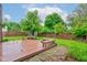 Spacious backyard featuring a wood deck, lush lawn, wooden fence, and mature trees offering a serene outdoor space at 7918 Bitternut Dr, Indianapolis, IN 46236