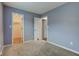 Bedroom with walk-in closet, neutral carpet, and light blue painted walls at 7918 Bitternut Dr, Indianapolis, IN 46236