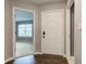 A home entryway with hardwood floors, a large white front door, and open doorway into a living space at 7918 Bitternut Dr, Indianapolis, IN 46236