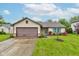 Charming ranch-style home featuring a two-car garage, well-maintained lawn, and colorful flower beds at 7918 Bitternut Dr, Indianapolis, IN 46236
