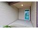 A well lit covered front porch with green trim on the entry door at 7918 Bitternut Dr, Indianapolis, IN 46236