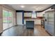 Bright kitchen with stainless appliances, island, and sliding glass door leading to a fenced backyard at 7918 Bitternut Dr, Indianapolis, IN 46236