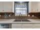 Modern kitchen sink featuring updated fixture and backsplash at 7918 Bitternut Dr, Indianapolis, IN 46236