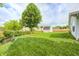 Well maintained lawn featuring a shade tree, flower bed, shed, and new wooden fence at 852 Yellowwood Dr, Greenwood, IN 46143
