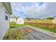 View of backyard featuring a wooden deck, new wooden fence and shed against cloudy skies at 852 Yellowwood Dr, Greenwood, IN 46143
