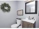 Well-lit bathroom with modern fixtures, a wood-look vanity, and decorative wreath offers a tranquil and stylish space at 852 Yellowwood Dr, Greenwood, IN 46143