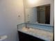 Bathroom vanity with a white marble countertop and a large mirror at 8609 Stonewall Dr, Indianapolis, IN 46231