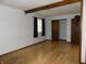Bedroom with laminate flooring, decorative beam, and a large closet at 8609 Stonewall Dr, Indianapolis, IN 46231