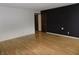 Spacious living room with laminate flooring and a contrasting black accent wall at 8609 Stonewall Dr, Indianapolis, IN 46231