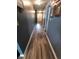 Long hallway featuring gray walls, wood-look floors, white trim, and photo decorations at 878 Sommersweet Run, Greenwood, IN 46143