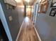 Hallway with gray walls and wood-look floors leads to a bright white door at 878 Sommersweet Run, Greenwood, IN 46143