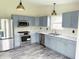 Modern kitchen featuring stainless steel appliances, gray cabinets and wood grain flooring at 883 Halyard Dr, Avon, IN 46123