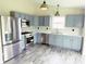 Modern kitchen featuring stainless steel appliances, gray cabinets and wood grain flooring at 883 Halyard Dr, Avon, IN 46123