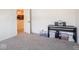 Bright bedroom with light-gray carpet features a piano and open door leading into the kitchen at 9001 Fitzgerald Dr, Indianapolis, IN 46239