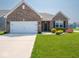 A brick house featuring a two-car garage, a green lawn and colorful landscaping at 9001 Fitzgerald Dr, Indianapolis, IN 46239