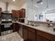 Well-lit kitchen features stainless steel appliances, dark wood cabinets, tile backsplash, and tile flooring at 9001 Fitzgerald Dr, Indianapolis, IN 46239