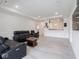 Bright, open-concept living room featuring modern light grey flooring and a comfortable black leather sofa set at 9001 Fitzgerald Dr, Indianapolis, IN 46239