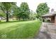 Spacious backyard featuring mature trees, a lush green lawn, and access to the covered patio at 9133 Log Run N Dr, Indianapolis, IN 46234