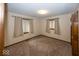 Neutral bedroom showcasing multiple windows, carpeted floors, and overhead lighting at 9133 Log Run N Dr, Indianapolis, IN 46234