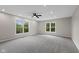 Spacious bedroom featuring neutral colored walls, plush carpet, a ceiling fan, and sun-filled windows at 9148 Oak Knoll Ln, Fishers, IN 46037