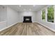 Bright living room features a black fireplace, wood floors and large windows with scenic backyard views at 9148 Oak Knoll Ln, Fishers, IN 46037