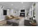 Sun-filled living room featuring a fireplace, hardwood floors, modern decor, and comfortable seating at 9148 Oak Knoll Ln, Fishers, IN 46037