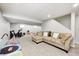 Finished basement showing neutral walls, carpet, exercise equipment, toys, and a large sectional sofa at 10717 Windermere Blvd, Fishers, IN 46037