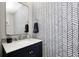 Stylish half bathroom featuring unique wallpaper, a modern mirror, and a sleek vanity at 10717 Windermere Blvd, Fishers, IN 46037
