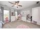 Bright bedroom featuring a ceiling fan, neutral walls, white trim, and a play area with a tent at 10717 Windermere Blvd, Fishers, IN 46037